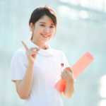 人差し指を立てる白衣の女性